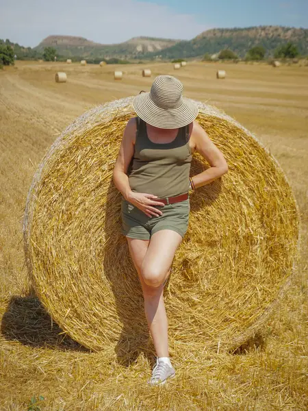 Pipet balyaların yanındaki şapkalı kadın.