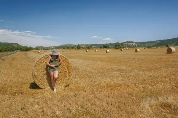 Pipet balyaların yanındaki şapkalı kadın.