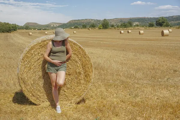 Pipet balyaların yanındaki şapkalı kadın.