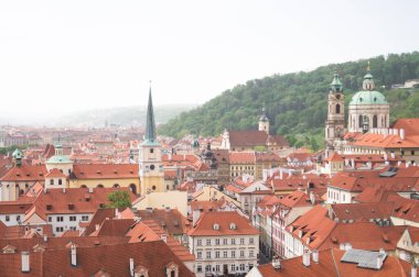 Prag, Çek ve Çekçe 'deki eski kentin panoramik manzarası. Eski binaların kırmızı çatıları. Eski mimari. Kasabanın üzerinde gerçek bir sis var. Gün, yaz, bahar. Ziyaret için güzel bir yer.. 