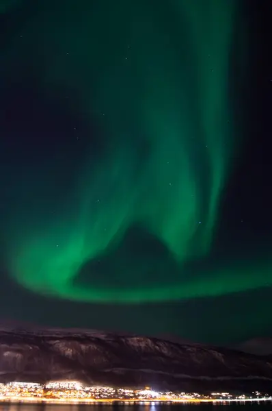 Green aurora borealis, northern light. Tromso, Norway. Winter in Norway. Skylights. Long exposure. Breathtaking. Cosmic energy. Night, sky. Visit Tromso. Nordic view. Night town reflecting in water.