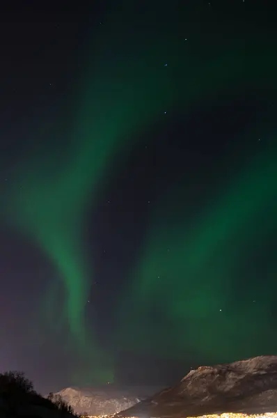 Green aurora borealis, northern light. Tromso, Norway. Winter in Norway. Skylights. Long exposure. Breathtaking. Cosmic energy. Night, sky. Visit Tromso. Nordic view. Night town reflecting in water.