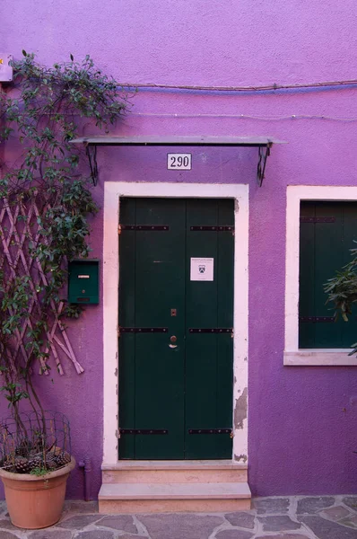 Burano adasında renkli bir bina. Venedik, İtalya 'da ziyaret edilecek bir yer. Binaların mutlu renkleri. İlham verici, parlak boya. Kapı, giriş, ev, geri dönüş, ahşap kapı.
