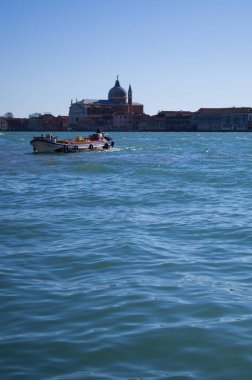 İtalya 'da Venedik' te gün ortasında. Tekne, su, deniz, Venedik 'te seyahat, Venedik ulaşımı, ufuk çizgisi. Eski tekne. Arkadaki Venedik. Mavi su. 