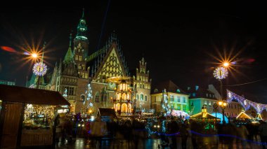 Wroclaw, Polonya 'da Noel büyüsü. Canlı ışıklar, hareketli kalabalık ve tarihi mimari ile aydınlatılmış pazar meydanı. Uzun süre maruz kalmak hayat ve hareket getirir.. 