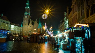 Noel zamanı ana meydanda bir festival sahnesi, tarihi saat kulesinin ışıltısı, hareketli pazar tezgahları ve ışıl ışıl dekorasyonların sergilendiği. Parlak ışıklar, yıldız patlaması da dahil..