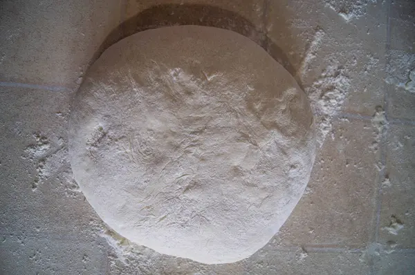 El değmemiş hamurlar hazır, fırıncı sanatı için bir tuval. Kabuklu ekmeklere ya da hassas hamur işlerine dönüşmeye hazır. Yemek pişirme sanatının kutlaması. Çiğ hamur, un tozuyla kaplanmış, sanatçının dokunuşunu bekliyor..