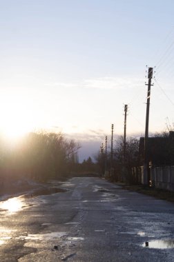 Ukrayna 'nın tuhaf bir kasabasında, yumuşak bir gökyüzünün altında, alacakaranlıkta ışıldayan sokaklar. Akşam ışığı kırsal araziyi yumuşatıyor, kasabanın yan yollarını yansıtıyor. Esmer renkler karlı bir köy yoluna yerleşir, Ukrayna 'da güne sessiz bir son..