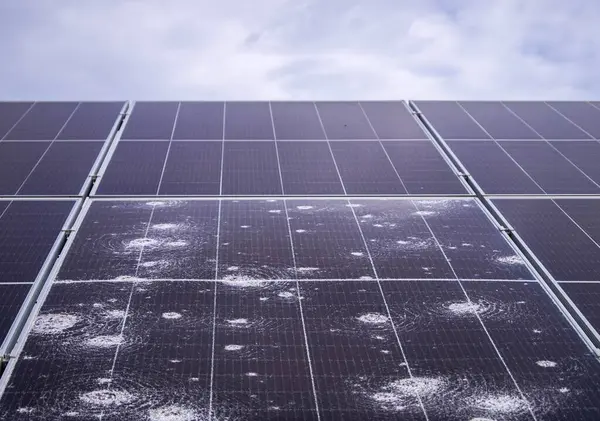 stock image Close-up of a solar panel with visible hail damage, illustrating the impact of severe weather on renewable energy infrastructure and efficiency.