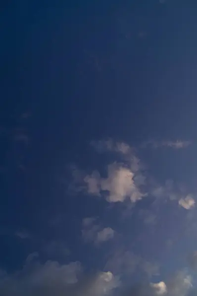 Koyu mavi tonlarla akşam gökyüzü ve Ukrayna kırsalında dağılmış bulutlar, geceye sakin ve huzurlu geçişi yansıtıyor..