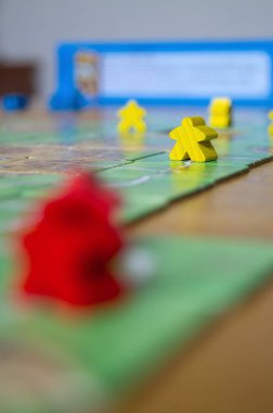 Yellow wooden game piece on a green board, symbolizing strategic moves in a tabletop game. clipart