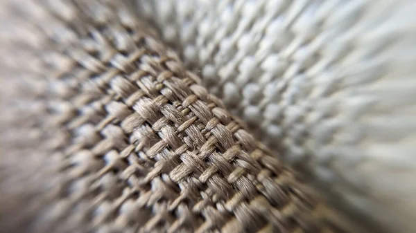 Macro photo of fabric, braided corners close up. Beige fabric in maxilla