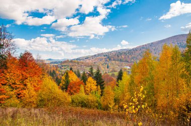 Sonbahar dağ manzarası beyaz bulutlu mavi gökyüzüne karşı