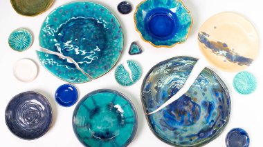 Beyaz arka planda mavi ve mavi tonlarda farklı boyutlarda seramik tabaklar. Beyaz arka planda kırılmış kil tabakaları