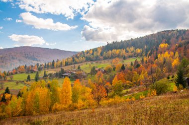 Sonbahar dağ manzarası beyaz bulutlu mavi gökyüzüne karşı