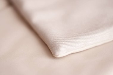 Yatak odasındaki yatak odasındaki dekoratif yatak örtüsünün bir parçası. Süt ve bej tonlarında yatak örtüsü. Yatak örtüsü.