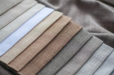 Perdeler ve dekoratif yastık kılıfları için beyaz, bej ve gri kumaşlar. Yakın çekim perdeleri için kumaş rengi paleti.