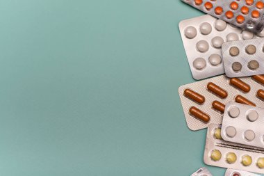 Mavi arka planda su toplamış haplar. Mavi arka planda ilaç ve haplarla kabarcıklar