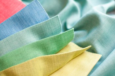 Yeşil arka planda sarı, yeşil ve mavi kumaş örnekleri. Perdeler için kumaş örnekleri