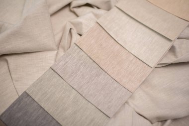 Ev yapımı tekstil ve perdeler için süt, bej ve gri renkli kumaş. Perdeler için kumaş örnekleri.