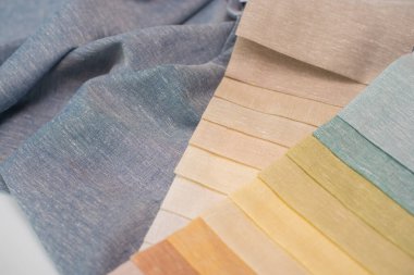 Pliseli mavi kumaşlı perdeler için açık renk kumaş örnekleri. Perdeler için keten kumaş