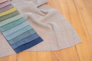 Ahşap arka plandaki perdeler için keten kumaş. Perdeler ve tüller için renkli kumaş örnekleri.