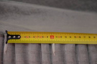 İnşaat ruleti perdelerin kıvrımlarında öfkeye uygulanır. Yakından kancalı perde.