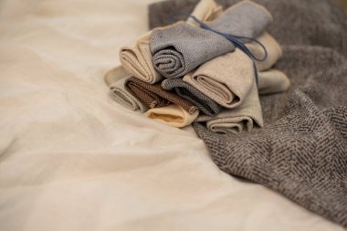 Perdeler için kumaş örnekleri süt dokusunun arka planında rulo şeklinde bükülür. Perdeler için sütlü gri kumaşlar. Doku örnekleri. Desenli kumaş