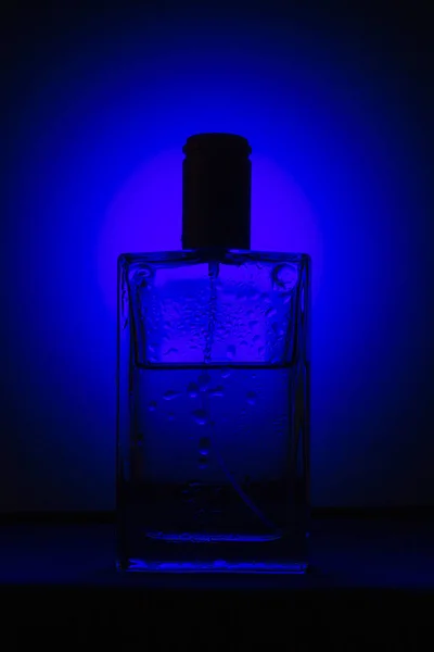 Perfume Bottle Black Background Blue Light — Stock Photo, Image