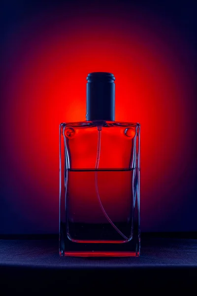黒の背景に赤い光の香水瓶 — ストック写真
