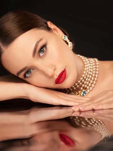 İnci küpeli ve kolyeli kırmızı dudaklı güzel kız.