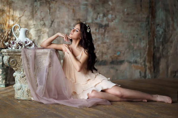 Baharda narin bir kız elinde çiçekle kumaşın arkasında