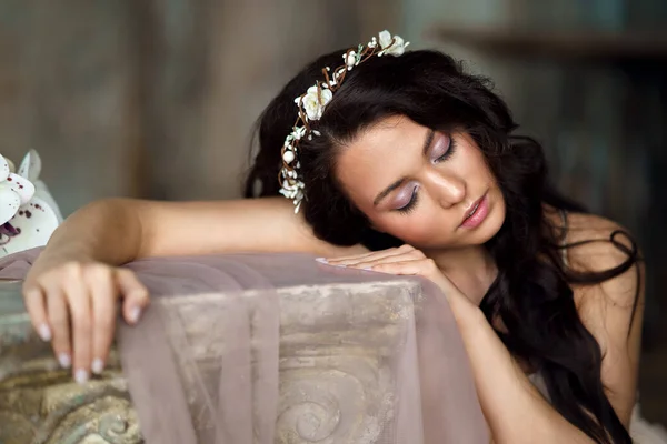 Baharda narin bir kız elinde çiçekle kumaşın arkasında