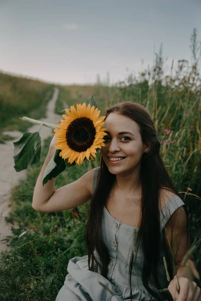 young beautiful woman in a sunflower field in a summer day