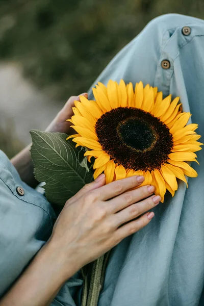 Ellerinde ayçiçeği olan genç bir kadın
