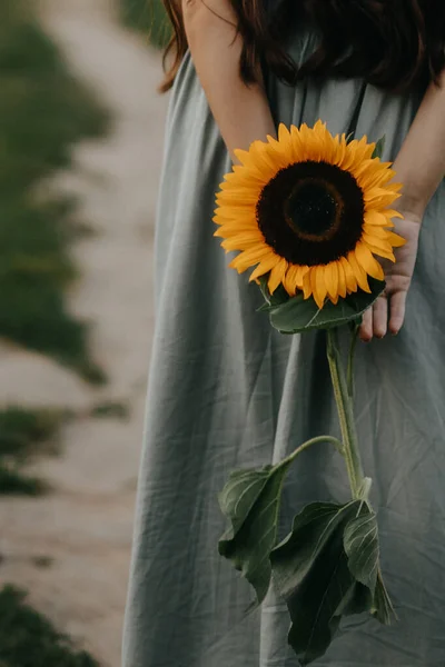 Ellerinde ayçiçeğiyle güzel genç bir kadın