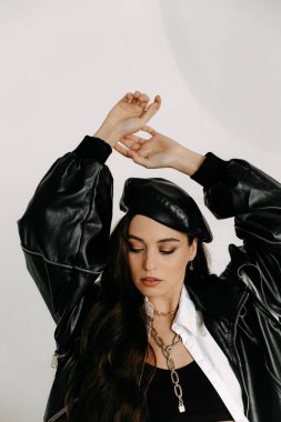 young beautiful woman in a black coat and leather jacket on a white background