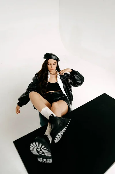 fashion studio shot of a beautiful young girl wearing black lingerie and white shirt, standing on a gray background