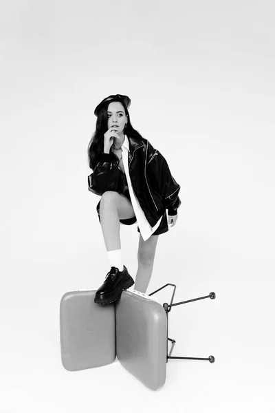 young woman with a bag of coffee and a suitcase on a white background