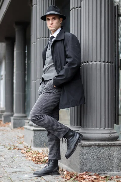 stock image Men's photo session in a classic checkered suit and hat against the backdrop of columns.