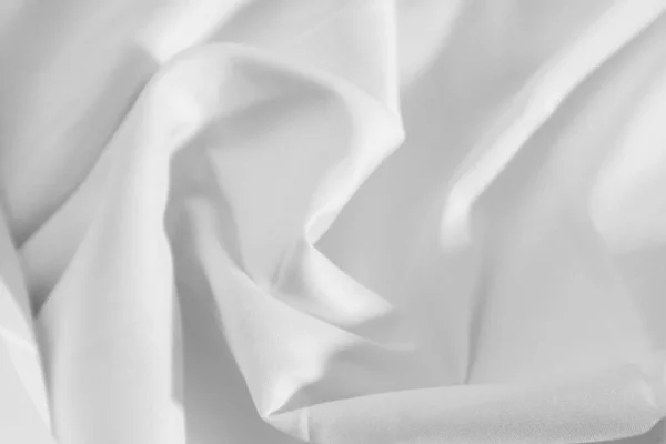 the white fabric\'s suppleness creases and shadows in fabrics