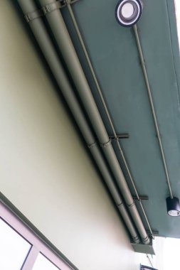 Elektrik sistemi çalışması, borular ve tavana yerleştirilmiş büyük kablolar.