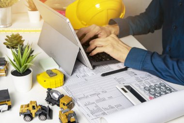 Mühendisler tasarım ve sistem çalışmaları, inşaat güvenliği, inşaat işi ve gayrimenkul üzerinde oturup çalışıyorlar.