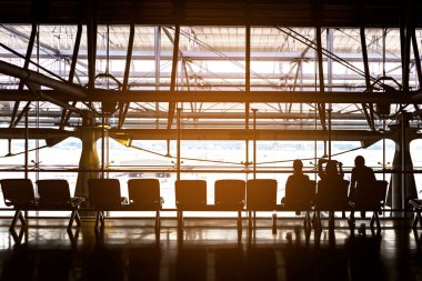 Havaalanında bekleyen, arka planda perspektif, havaalanında seyahat bekleyen, seyahat eden ve ziyaretlerini bekleyen insanların siluetleri.