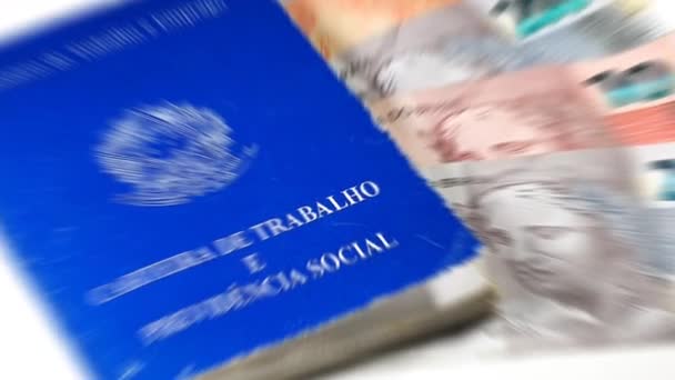 ブラジル連邦共和国 労働省 ブラジルの労働者カード Carteira Trabalho は白人の背景にブラジルのお金を持っている ブラジル経済の概念 — ストック動画
