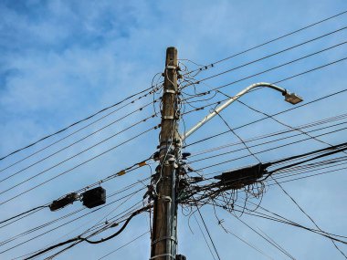Elektrik direği ve elektrik kabloları olan sokak lambası, düşük açılı görüş.