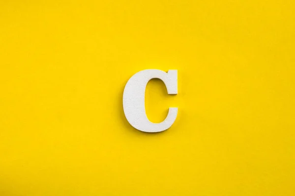文字C大文字 黄色の背景に白い木の文字 — ストック写真