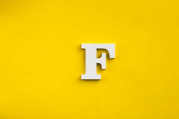 アルファベット文字F 黄色の背景に白い木の文字 — ストック写真