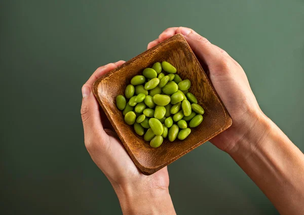 Glycine max - Fresh organic green soybeans in grower's hands
