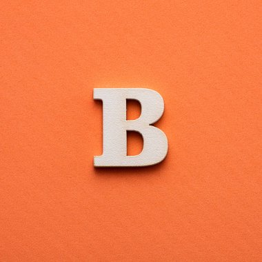 Alfabe harfi B - pembe arkaplanda beyaz ahşap harf